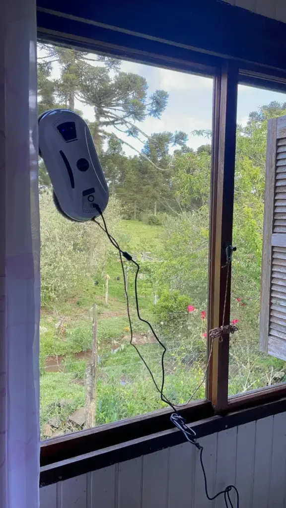 Robô Limpa Vidro PuRuikai sendo usado em uma janela interna.